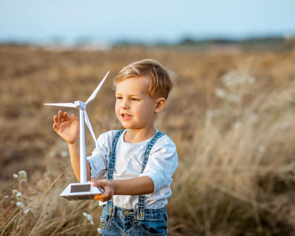 boy-playing-with-toy-wind-turbine-outdoors-2022-01-18-23-53-41-utc-min